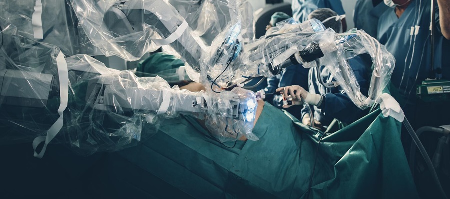 Photo of an operating table with surgical robots performing an operation and being isolated with special films.