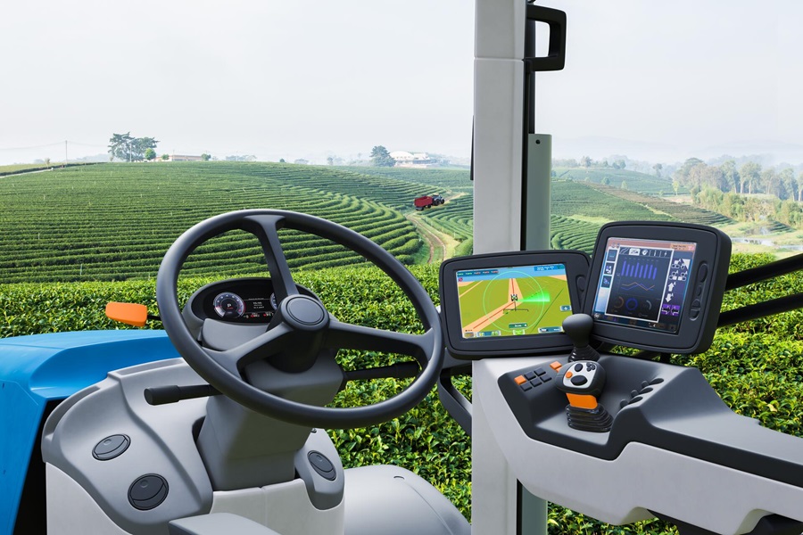 Interior view of a modern farming machine with digital screens in a field.
