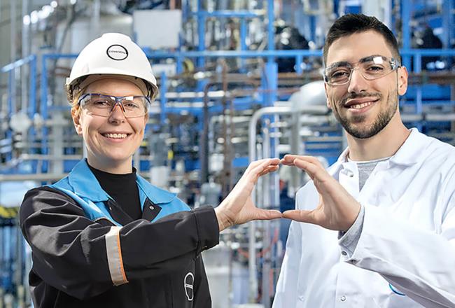 Two Covestro employees form a circle with their hands.