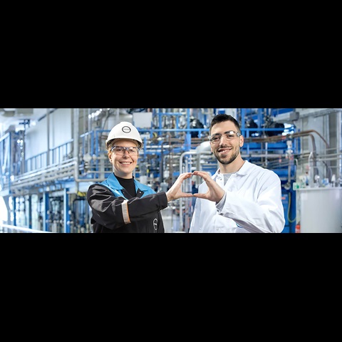 Two Covestro employees form a circle with their hands.