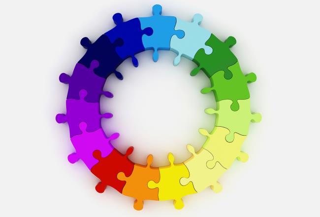 Colorful puzzle pieces that form several circles.