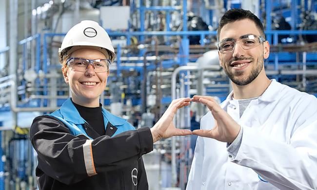 Two Covestro employees form a circle with their hands.